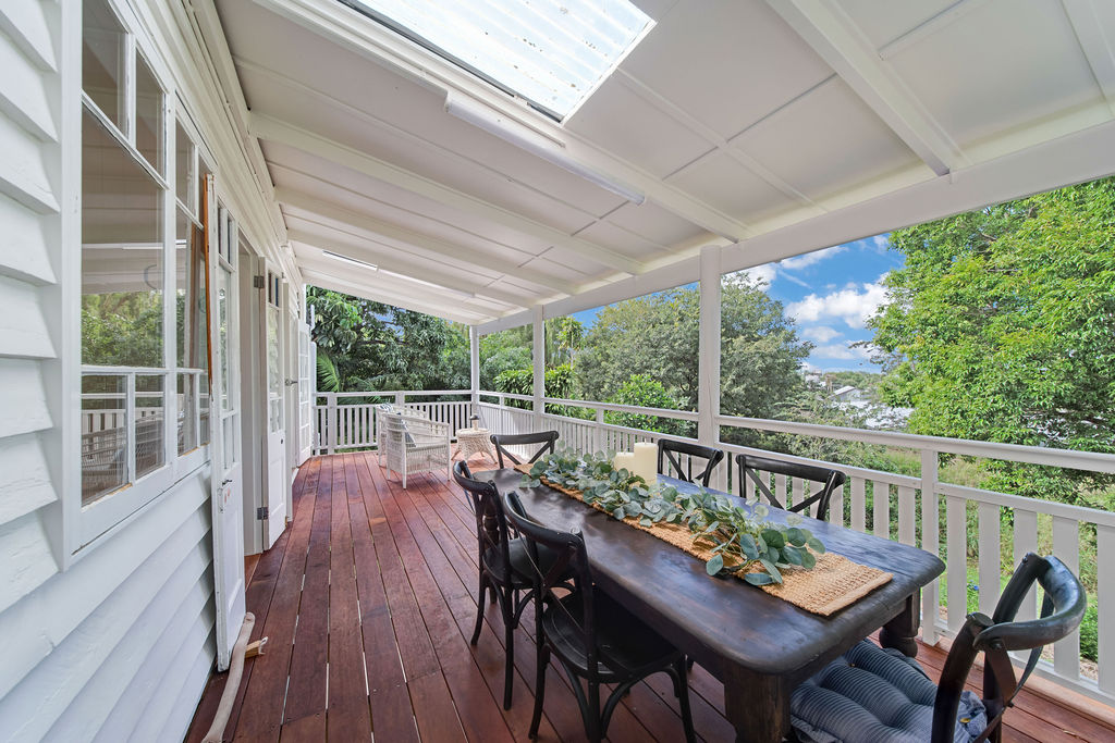 Front verandah with outdoor dining, white balustrade and restored timber decking.