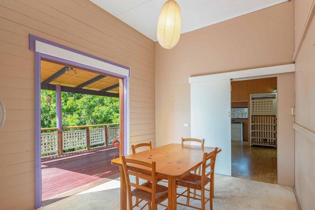 The room before renovation, with peach walls, carpet and a view through to the verandah and old kitchen.