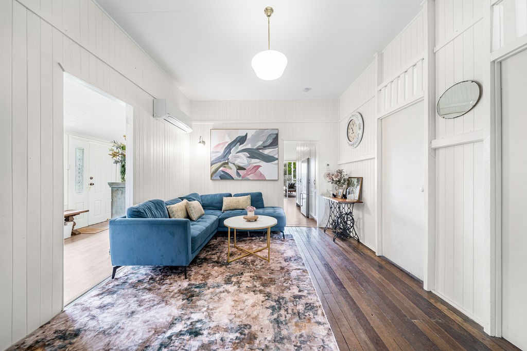 The dining room after renovation, opened into a fresh panelled room with colour, collected pieces and a blue sofa.
